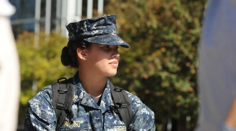 Woman in U.S. Navy fatigue with a bookbag on