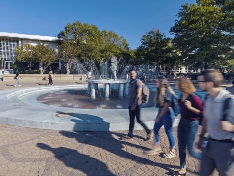 Students walking in front of fountain